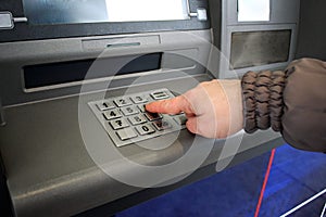 Close up of hand entering pin at an ATM. Female arms, ATM - entering pin.Woman using banking machine.