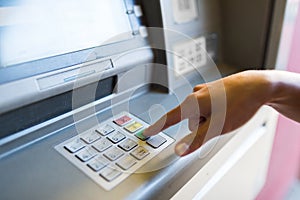 Close up of hand entering pin code at atm machine