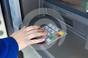 Close up of hand entering pin code at cash machine