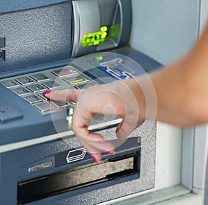 Close-up of hand entering PIN/pass code on ATM/bank machine keypad