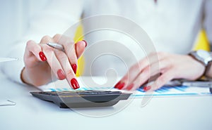 Close up hand of female accountant or banker making calculations. Savings, finances and economy concept