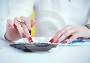 Close up hand of female accountant or banker making calculations. Savings, finances and economy concept