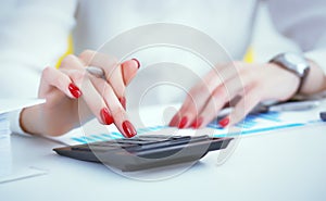 Close up hand of female accountant or banker making calculations. Savings, finances and economy concept