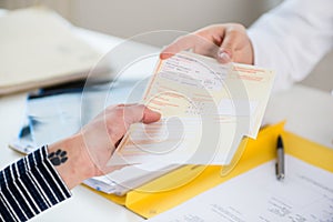 Close-up of the hand of a female patient receiving a prescription