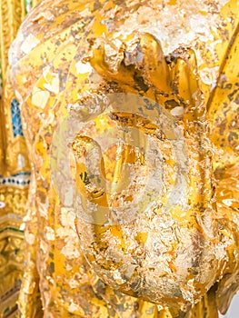 Close up hand filled with gold leaf of statue Buddha. concept shows the devotion of the Buddhists