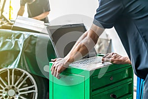 Close up hand finger of repairman touch laptop or computer notebook interfaced with car for repair during work investigate problem