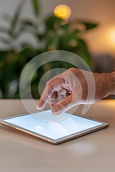 Close-up of a hand gently interacting with a glowing tablet screen in a soft-focused setting
