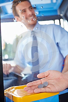 Close Up Of Hand Giving Driver Fare For Bus Journey