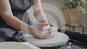 Close-up of the hand of a grumpy woman master works on a potter's wheel in slow motion. Making utensils with your own