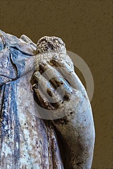 Close-up of hand of grungy old marble Greek or Roman statue holding a chipped and broken owl