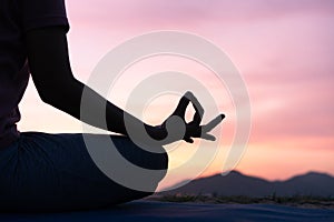 Close up hand and half body of health woman sit in lotus yoga position in the  sunset Practicing yoga makes meditation for healthy