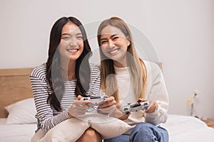 Close up hand.Happy LGBT lesbian couple holding joysticks and playing video game in relax day