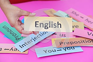 Close up hand hold paper card with text English. Concept, English language teaching.