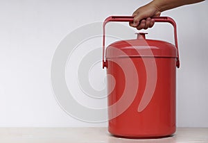 Close up hand hold red plastic bucket cooler.