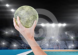 Close-up of hand holding ball and stadium in background