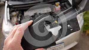 Close up of hand holding a car piece chewed through by rodent