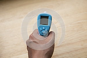 Close up of a hand holding a digital infrared thermometer thermometer gun isolated on white