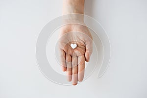 Close up of hand holding medicine heart pill