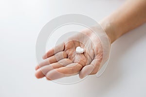 Close up of hand holding medicine heart pill