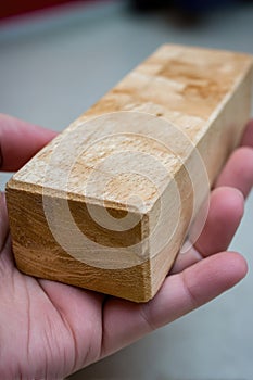 Close-up of hand holding rectangular wooden block