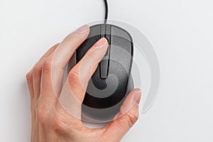 Close-up hand holding sleek black computer mouse on white background with copy space