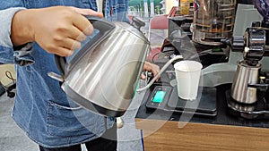 Close Up Hand holding a teapot for making coffee drink