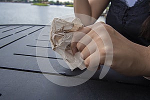 A close up of a hand holding a wrinkled up napkin