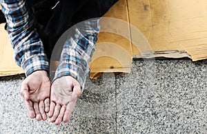 Close-up hand of homeless man and wish money from people on walking street.