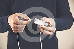 Close up of hand inserting a USB cable charger into portable power bank. Media. Close up of mans hand inserting a cable into