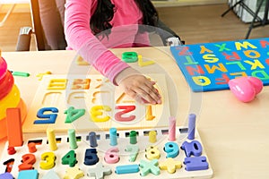 Close up hand of Little children playing with alphabet numbers puzzle