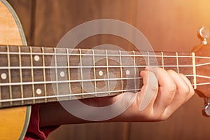 Close up finger Little Girl playing ukulele.