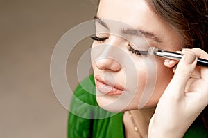 Makeup artist applies eyeshadow on eyes