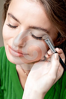 Makeup artist applies eyeshadow powder