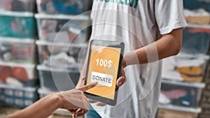 Close up of hand making donation by touching screen of tablet pc, Volunteers advertising or recommending app while