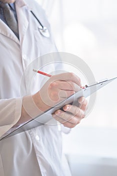 Close up Of Hand Male Doctor Filling The Medical Form. Close-up Of Male Doctor Filling The Medical Form. Doctor writting. Uniform