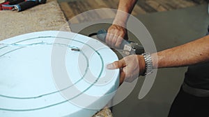 Close-up hand male worker cutting foam rubber for the production of a sofa in a furniture factory close-up shot, slow