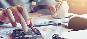 Close up hand man doing finance and calculate on desk about cost at home office