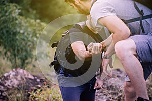 Close up of hand man getting help to bestfriends climb a rock,Helping hands,Overcoming obstacle concept