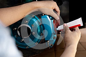 Close up hand a man holding brake pad and adding brake grease