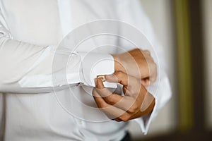 Close up of a hand man how wears white shirt and cufflink, with stones, luxurious wedding