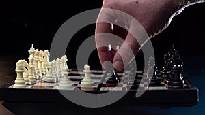 Close-up of the hand of a man playing chess. Close-up of man who is making move in chess game. Man and woman playing