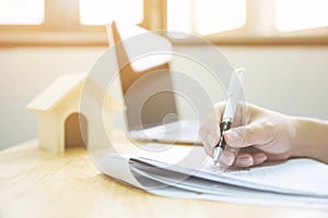 Close up hand of man signing signature loan document to home ownership