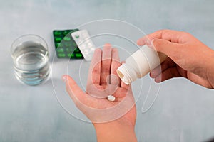 Close up hand man taking pills take a medicine,cup glass of water on table. Stop drug use Taking Medication health care