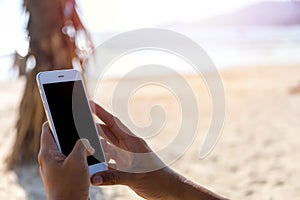 Close up hand man use mobile smart phone on the beach. Phone with black screen. With copy space for text or design