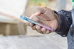 Close up hand of a man using mobile smart phone