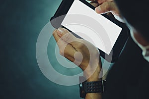 Close up of hand of man using mobile smart phones in the dark