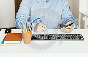 Close-up of hand man using a mouse and typing on keyboard on white table, business concept