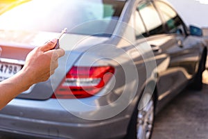 Close up hand man using remote for open car.transport