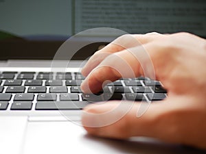 Close up of a hand of a man working over a laptop computer and using the track pad