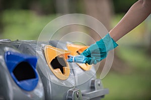 Close-up of a hand, mask and trash bin